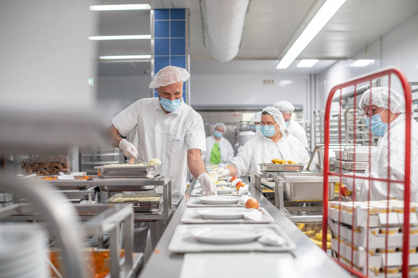 In der Küche werden die Patientenessen am Band portioniert.