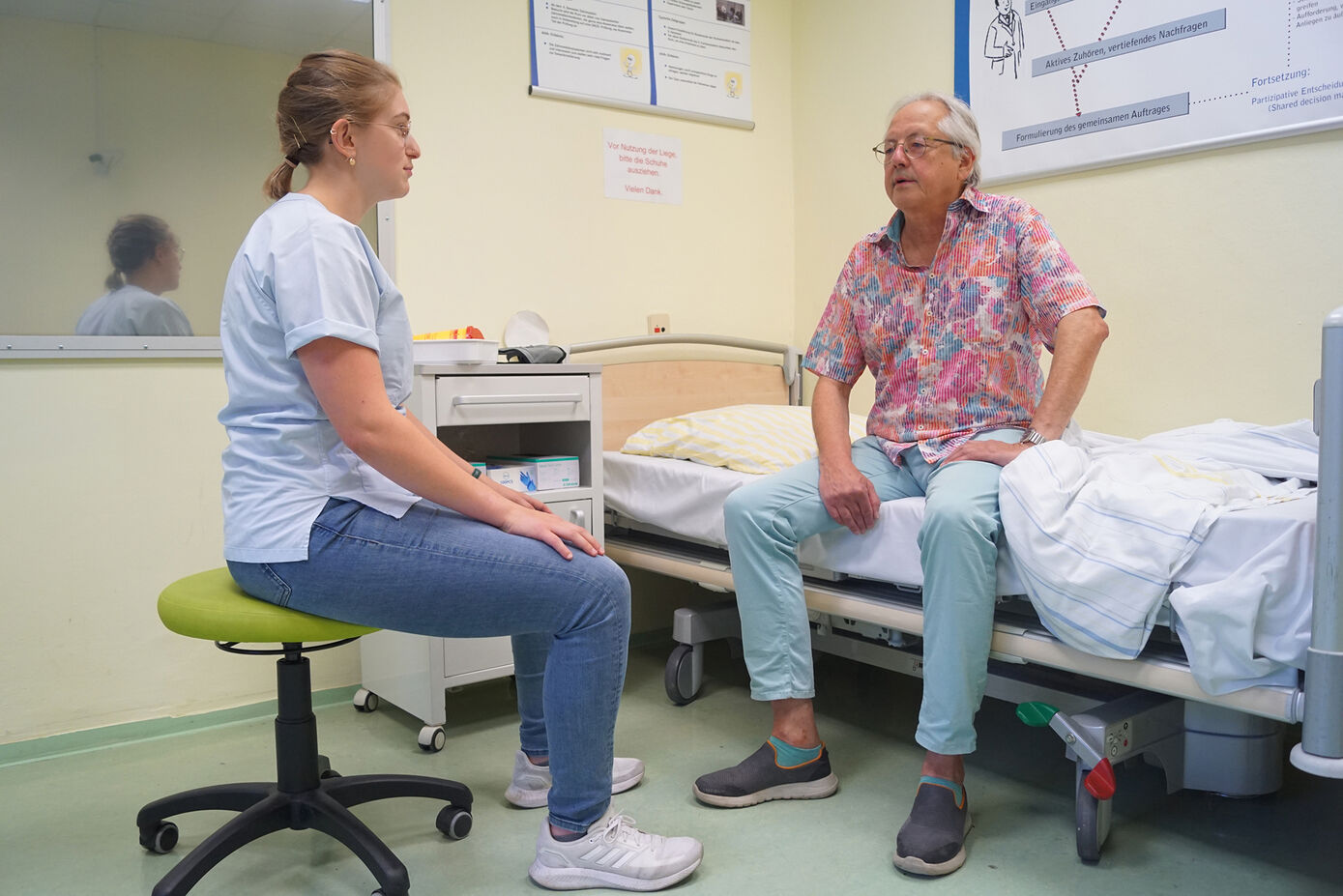 Medizinstudentin Sarah Maria Haberbosch im Gespräch mit Schauspielpatient Günter Platzdasch. Foto: UKJ