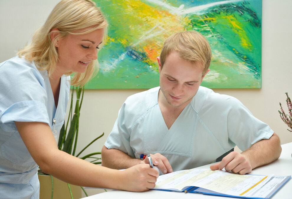 EIn angehender Krankenpflegefachmann bei der Dkumentation.