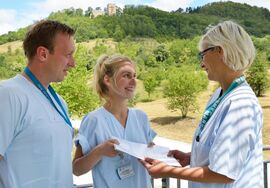 Sebastian Haubner, Ausbildungsleiter am UKJ, und Kati Egerland, Pflegeleitung am UKJ, übergeben den Arbeitsvertrag an Lena Kadur. Foto: UKJ