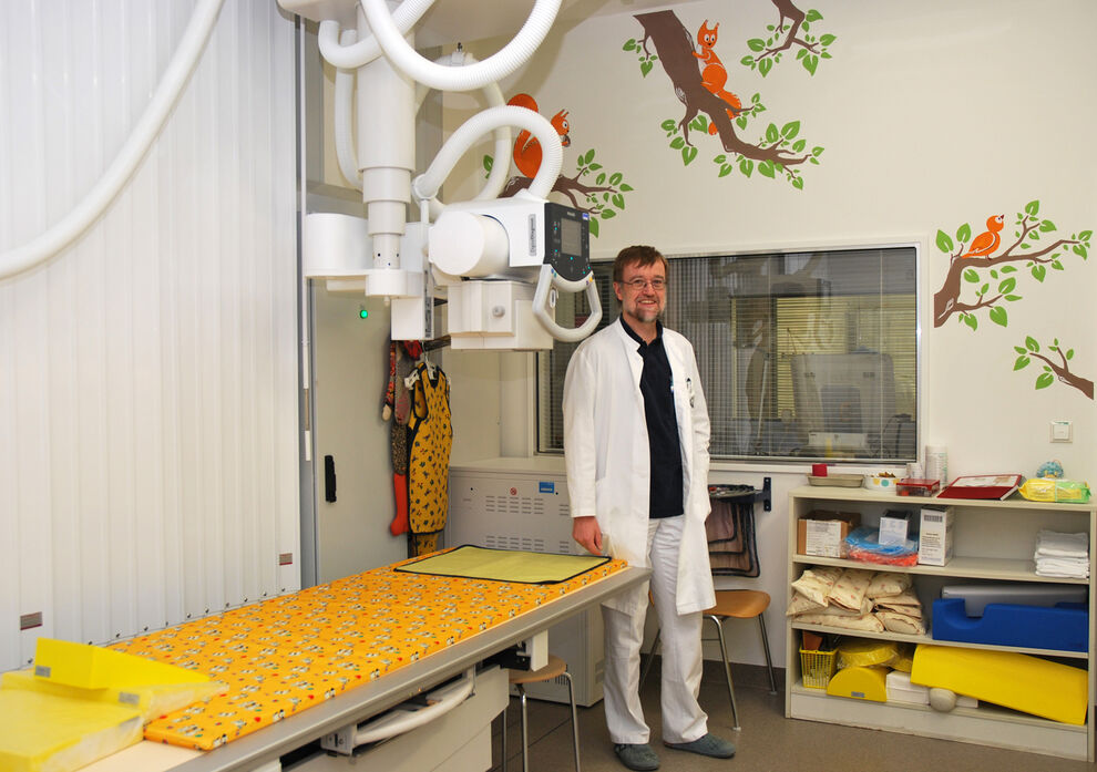 Prof. Dr. Hans-Joachim Mentzel, Leiter der Sektion Kinderradiologie im Institut für Diagnostische und Interventionelle Radiologie am UKJ, ist von der neuen Wandgestaltung im Röntgen-Untersuchungsraum begeistert. (Foto: UKJ/Emmerich)