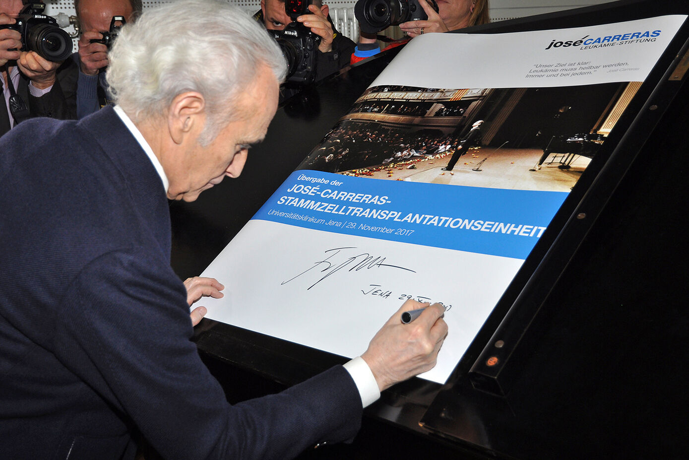 José Carreras unterzeichnet ein Plakat, das zur Erinnerung auf der neuen Station aufgehängt wird. Foto: Schacke