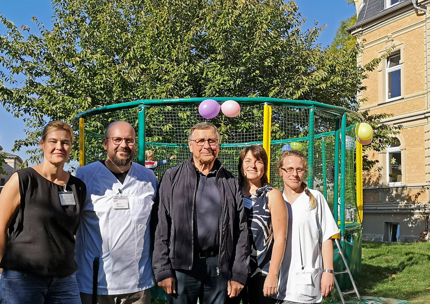 Melanie Rudovsky, Oberärztin der Kinderstation und der Tagesklinik „Zauberzwerge“, Erzieher Stefan Julius, Prof. Felix Zintl, Dr. Christina Filz, kommissarische Direktorin der Klinik für Kinder- und Jugendpsychiatrie, Psychosomatik und Psychotherapie, und Stationsleitung Katrin Rapprich weihen gemeinsam mit den kleinen Patienten das neue Trampolin ein. Foto: UKJ