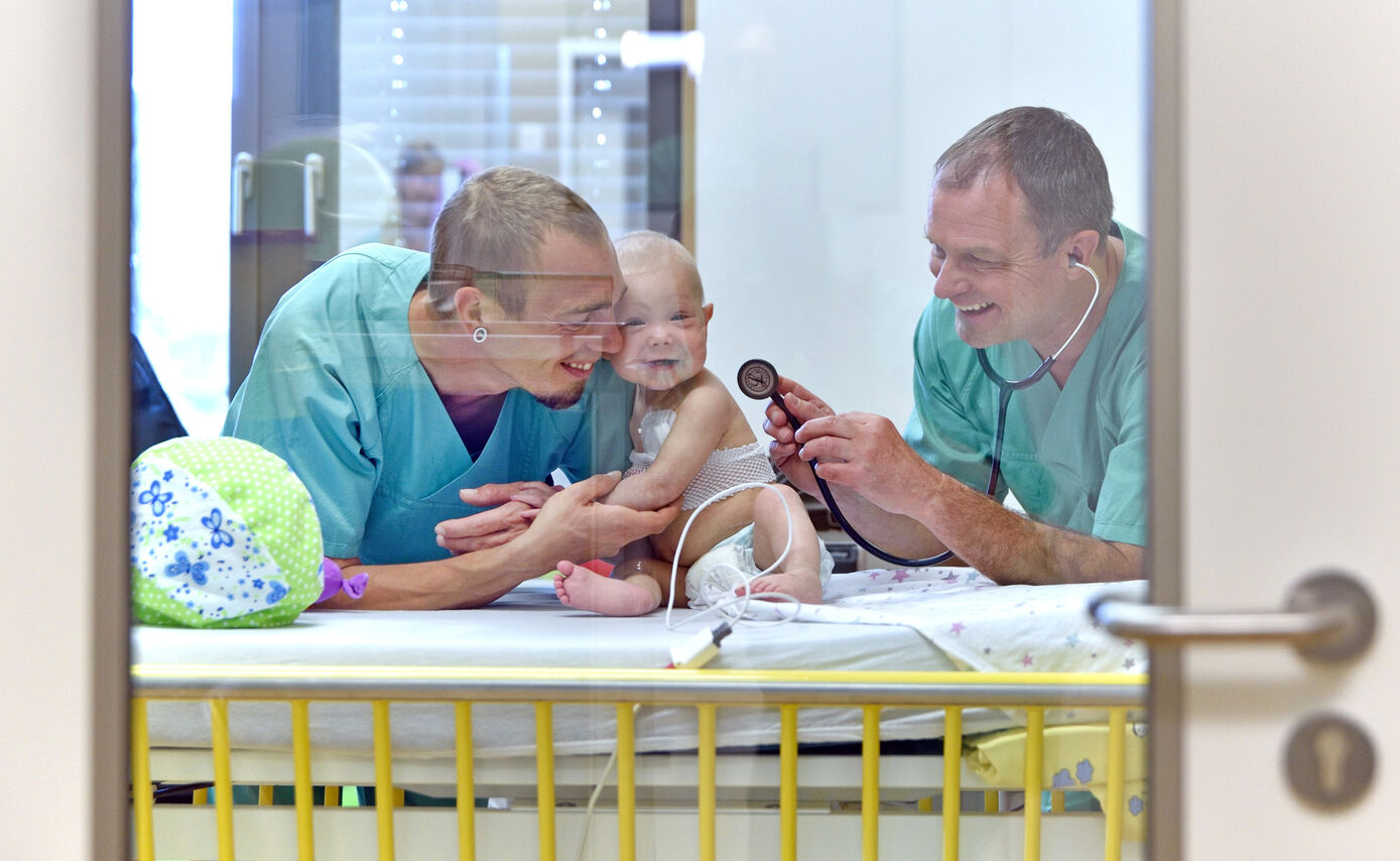 Prof. Dr. Bernd Gruhn, Oberarzt an der Klinik für Kinder- und Jugendmedizin am UKJ (re.), konnte Yunas seltene sehr unreife akute lymphoblastische Leukämie mit einer individuellen Antikörpertherapie erfolgreich behandeln. Yunas Eltern waren während der Behandlung ihrer Tochter stets vor Ort. Foto: UKJ/ Szabó