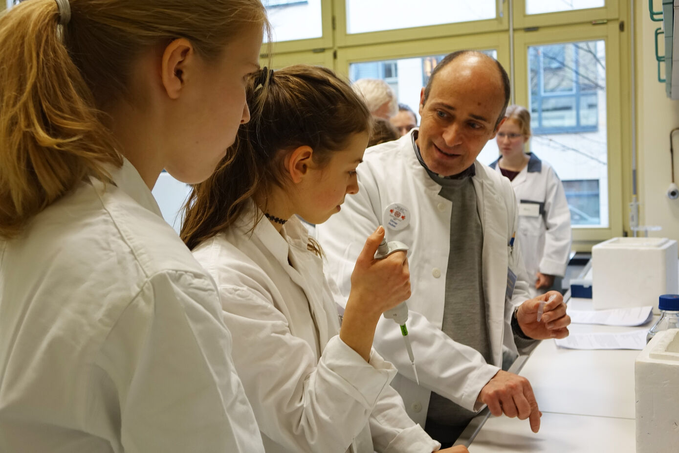 Prof. Dr. Otmar Huber (rechts), Direktor des Instituts für Biochemie II, erklärt, worauf beim Pipettieren zu achten ist. Foto: UKJ/Emmerich