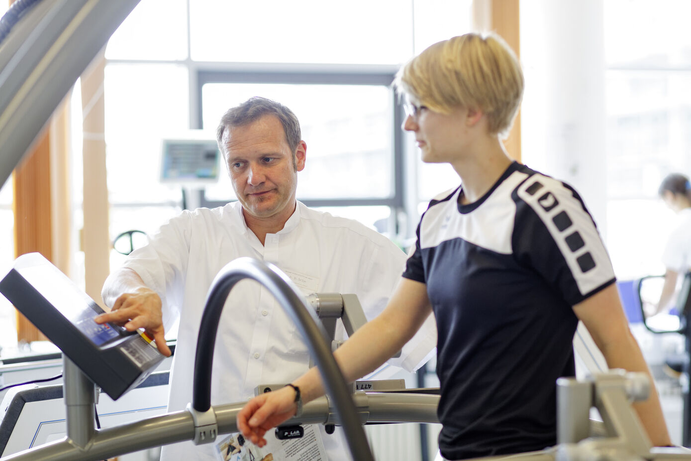 Dr. Steffen Derlien (l.), Sportwissenschaftler des Instituts für Physiotherapie am Universitätsklinikum Jena (UKJ), erklärt im Patientenseminar, warum Bewegung Multiple Sklerose-Patienten hilft.