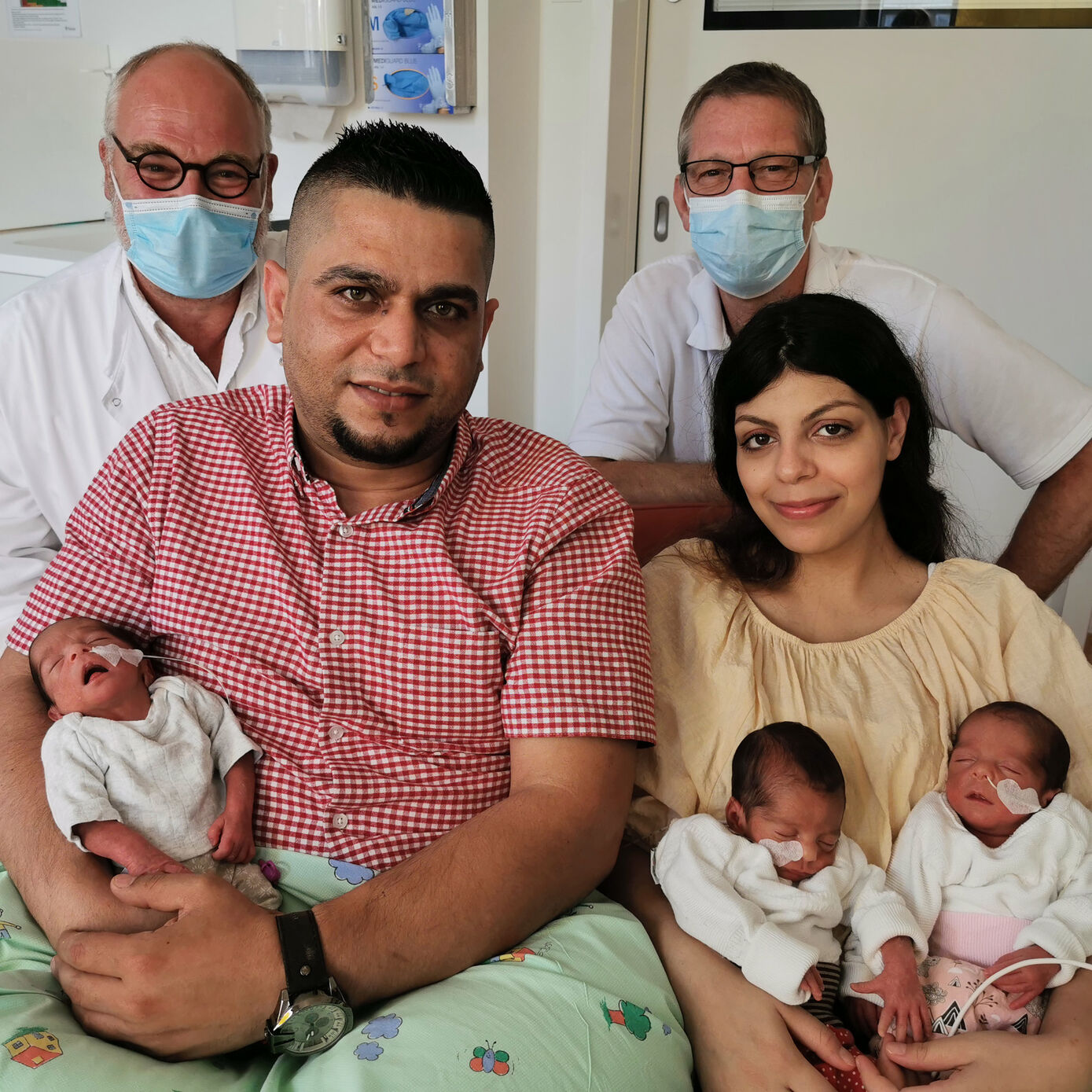 Im Vordergrund die stolzen Drillingseltern Papa Mohamad Baker und Mama Aya Alsadi mit den Mädchen Minas, Maria und Majar. Im Hintergrund Prof. Ekkehard Schleußner (links) und Prof. Hans Proquitté. Foto: UKJ