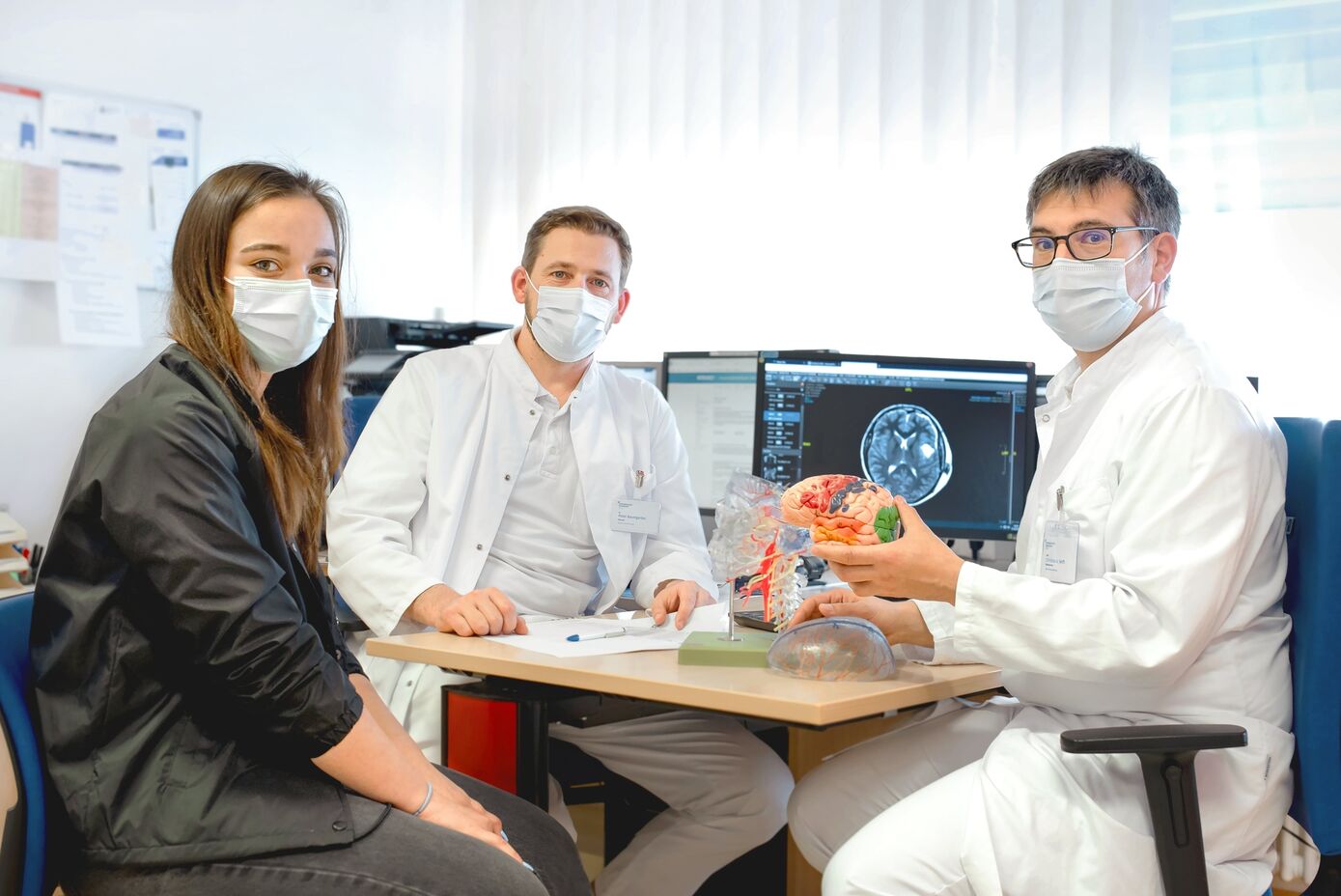 Zwei Monate nach der Wach-OP: Vanessa hat einen Nachkontrolltermin bei Dr. Peter Baumgarten, Oberarzt der Klinik für Neurochirurgie und Klinikdirektor Prof. Dr. Christian Senft am Universitätsklinikum Jena (v.l.n.r.). Foto: UKJ