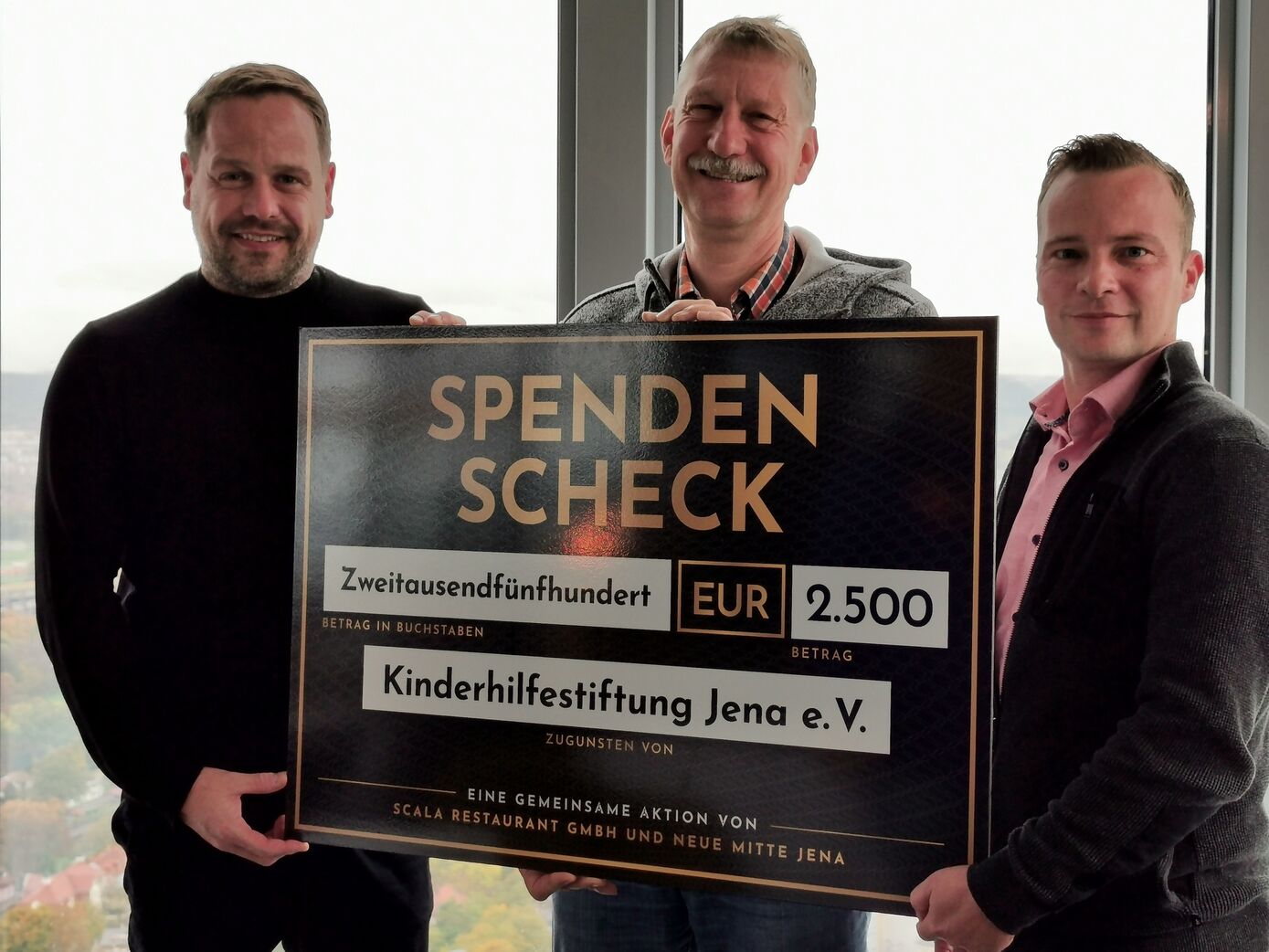 Christian Hempfe (Restaurant Scala), Prof. Dr. med. Hans Proquitté (Kinderstiftung Jena e.V. & UKJ), sowie David Haun (Neue Mitte Jena) bei der Spendenübergabe in luftiger Höhe.