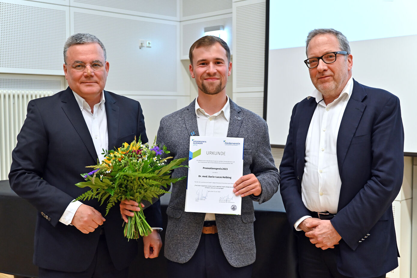 Dario Lucas Helbing (Mitte) wurde von PD Dr. Dr. Michael Kiehntopf (links), Vorsitzender des Fördervereins des Universitätsklinikum Jena, und Dekan Prof. Dr. Thomas Kamradt mit dem Promotionspreis geehrt. Foto: UKJ