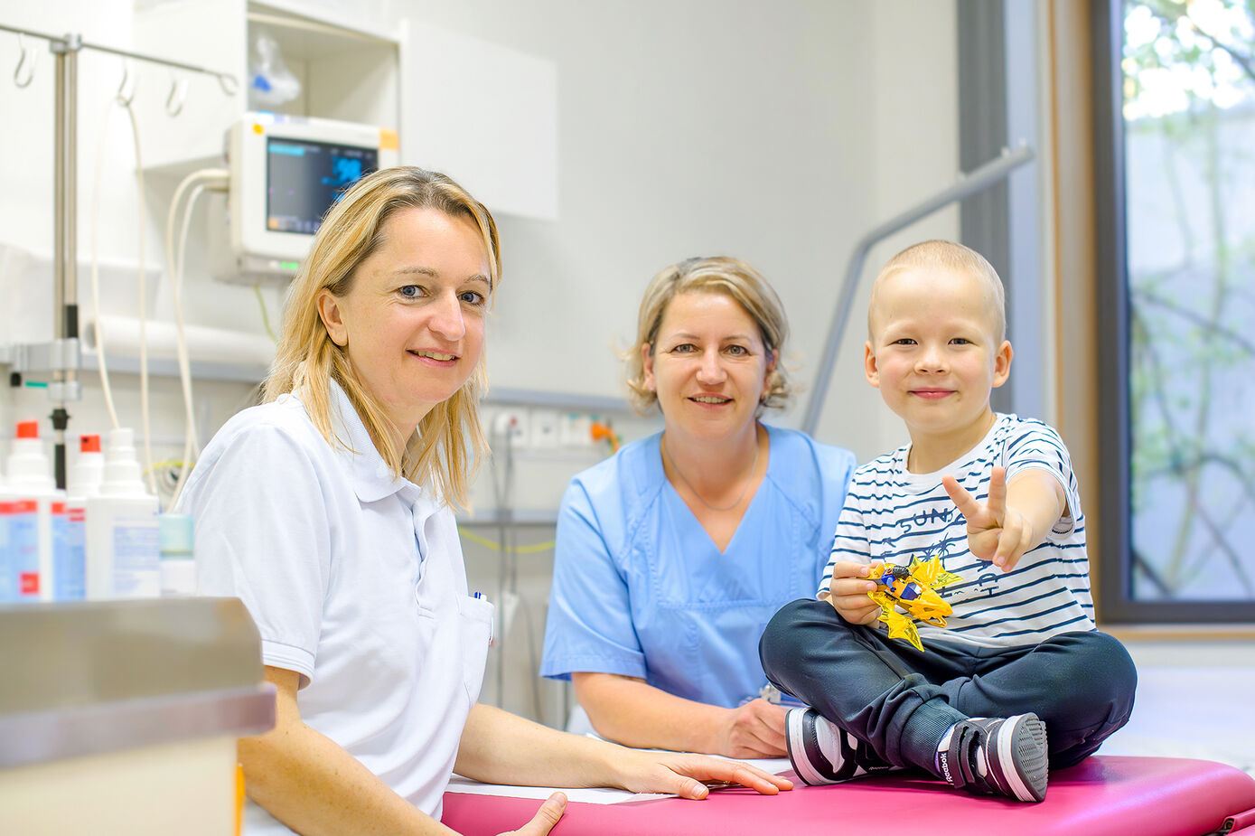 Dr. Jana Ernst, Oberärztin der kinderonkologischen Tagesklinik (li), und Kinderkrankenschwester Yvonne Weise gemeinsam mit Fritz im Untersuchungsraum der kinderonkologischen Tagesklinik am UKJ. Foto: Rodigast/UKJ