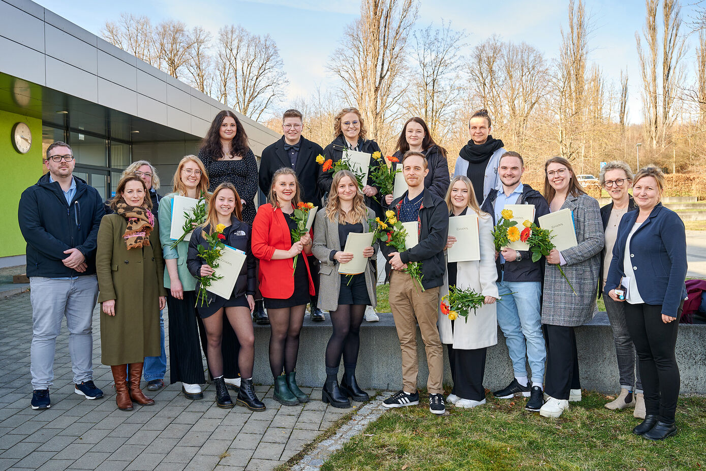 Freudestrahlend halten die Absolventinnen und Absolventen der generalistischen Pflegeausbildung ihre Zeugnisse in den Händen. (Foto: Hellmann/UKJ)