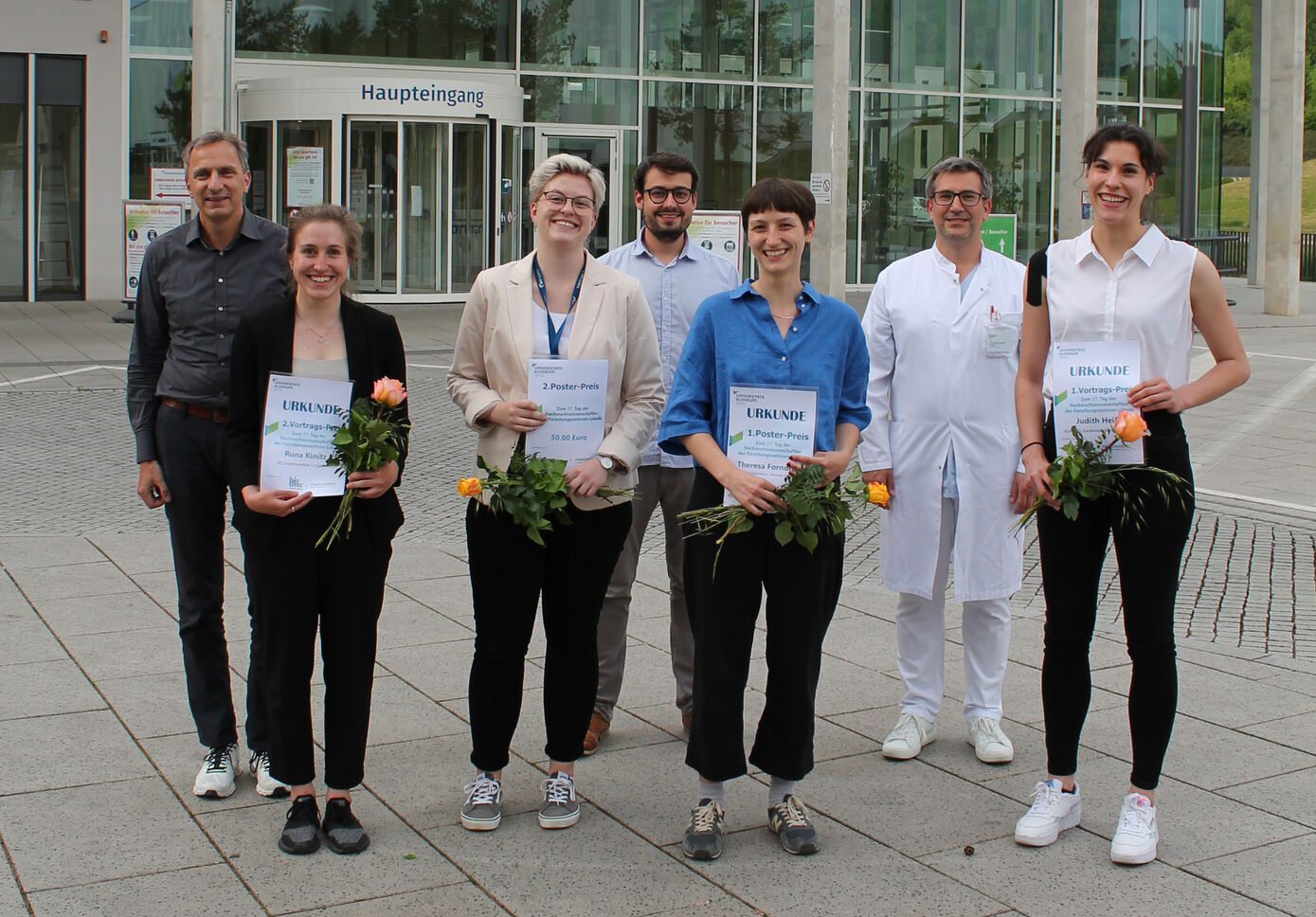 Die Preisträgerinnen Runa Kinitz, Maria Warschinke, Theresa Forndran und Judith Heiß (vorn) und die Jurymitglieder Prof. Peter Huppke, Prof. Florian Meier-Rosar und Prof. Christian Senft (hinten, v.l.). Foto: Dana Eppen/UKJ 