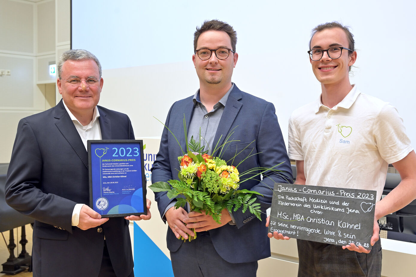 Medizinphysiker Christian Kühnel erhielt den diesjährigen Lehrpreis aus den Händen von Sam Quaas (r.) von der Fachschaft Medizin und Fördervereinsvorsitzenden PD Dr. Dr. Michael Kiehntopf. Foto: Michael Szabó/UKJ