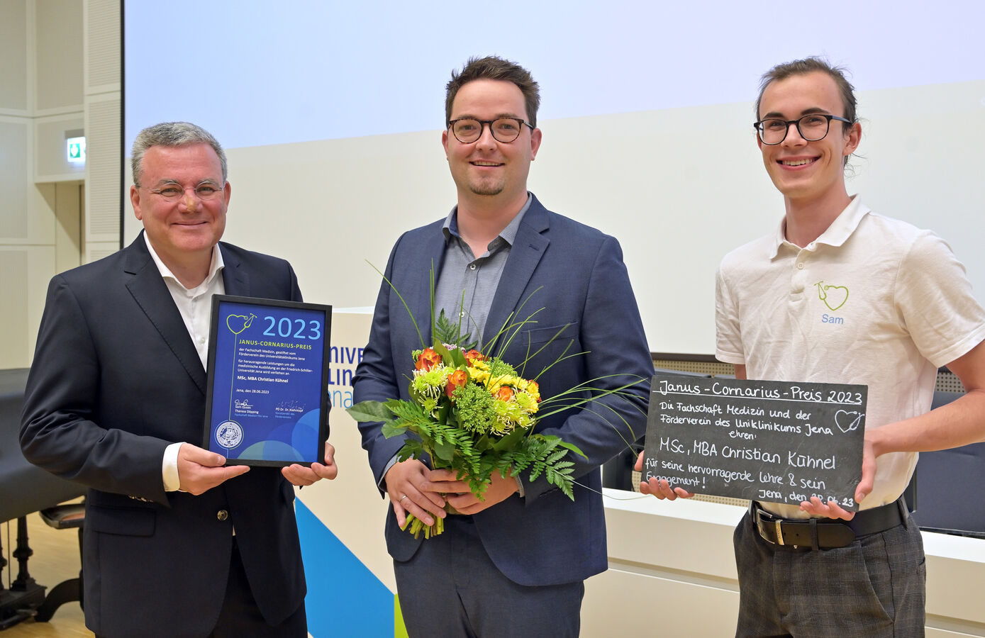 Medizinphysiker Christian Kühnel erhielt den diesjährigen Lehrpreis aus den Händen von Sam Quaas (r.) von der Fachschaft Medizin und Fördervereinsvorsitzenden PD Dr. Dr. Michael Kiehntopf. Foto: Michael Szabó/UKJ
